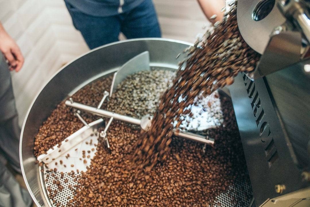 Closeup of grains pouring into industrial processing equipment